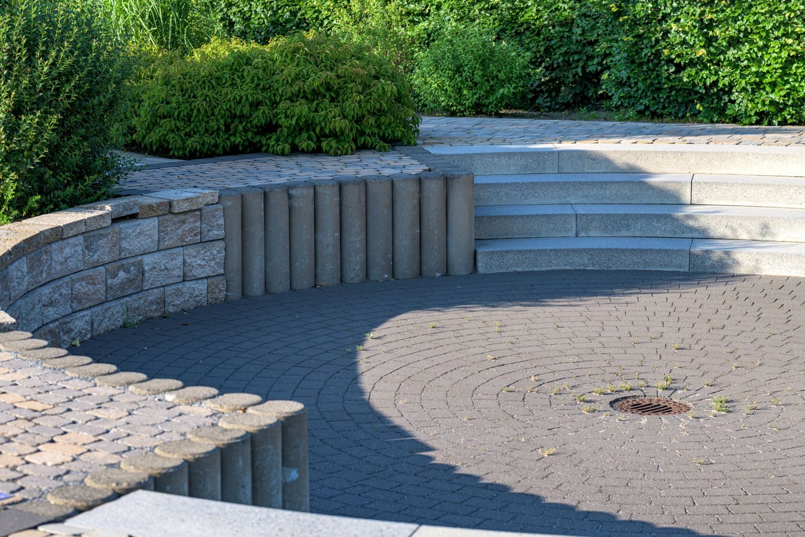 A paved garden terrace with retaining wall and steps